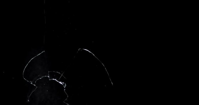 Shattered and broken glass shards flying through the air after crush broken window on a black background