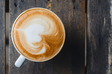 close up modern hot black coffee the cappuccino on wood background with coffee bubble foam pattern and texture in white cup looking and feel so delicious on glasses table in coffee shop.