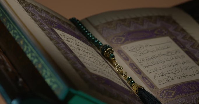 Holy Quran on Book Rest with Prayer Beads Close Up Rotation 2 Loop