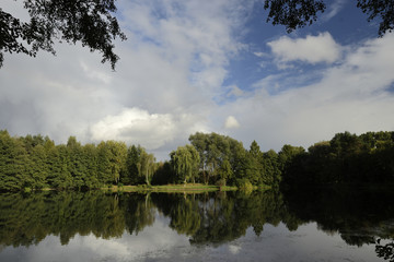 Lake in the forest in autumnal colors and blue sky