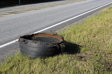 Exploded tire of semi truck on highway roadside.