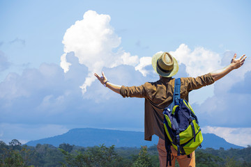 Male tourists with backpack standing outdoors with arms spread,Man enjoying with the top of the mountain.concept of travel and freedom