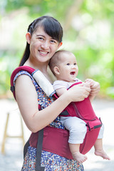 baby feeling happy and smiles with her mother in the garden.Portrait of Asian family.