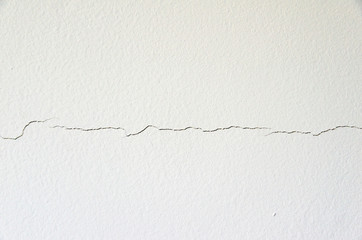 Crack on the wall. Shift foundations on the building and extended bricks. Building problems or consequence of earthquake in the active area. White wall shows everything. Risk of building collapsing