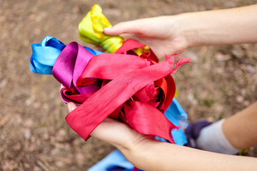 Close up view of female hands holding colored ribbon.