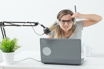 Radio host, streamer and blogger concept - Woman working as radio host at radio station sitting in...