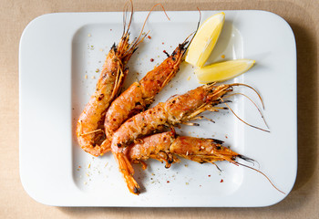 King prawns with lemon. Shrimps on a plate with lemon slices.