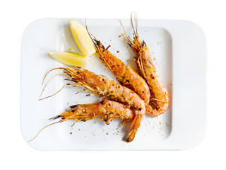 King prawns with lemon. Shrimps on a plate with lemon slices.