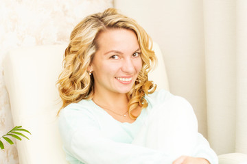 Naklejka premium Portrait of a beautiful, gentle, sexy young woman with a sweet smile in pajamas at home.