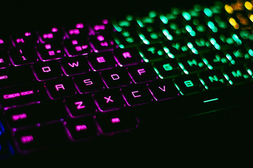 RGB notebook keyboard in the dark room. Soft bokeh.