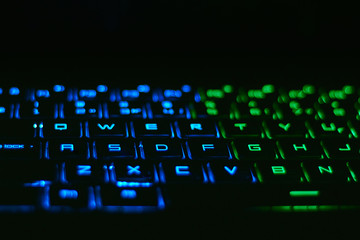 RGB notebook keyboard in the dark room. Soft bokeh.
