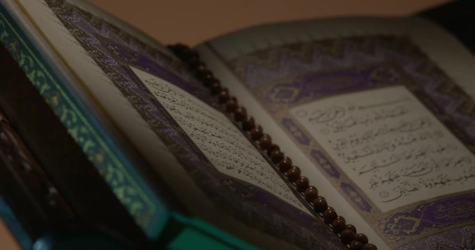 Holy Quran on Book Rest with Prayer Beads Close Up Rotation Loop