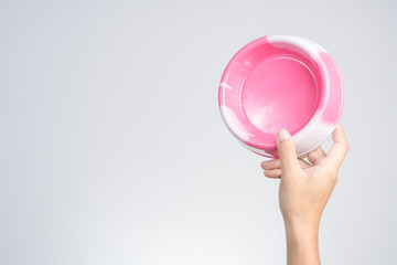Hand holding plastic pet food bowl