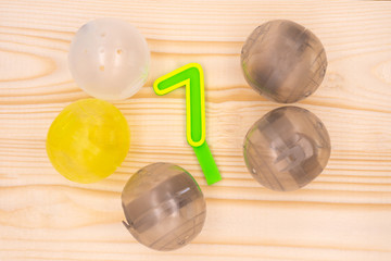 Gashapon, gray, yellow, white with 7 is the Lucky number on Yellow wooden table