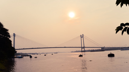 Sunset over Vidyasagar Setu (a modern Cantilever Spar Cable-Stayed Bridge) in a summer evening on...