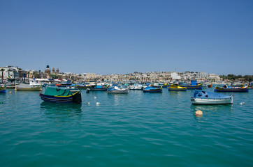 Fototapeta na wymiar Harbor of Marsaxlokk, a traditional fishing village located in the south-eastern part of Malta.