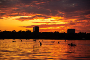 Bucharest sunset on Herastrau lake with kayak , people having relaxing and fun time