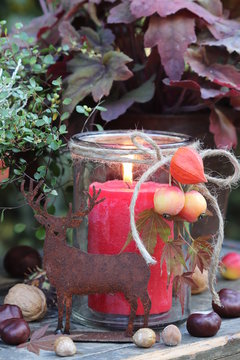 Herbst-Dekoration mit Rost-Hirsch und roter Kerze Stock Photo