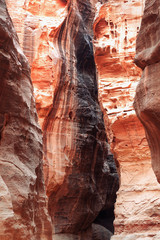 Jordan: rock face of a canyon in red, orange, yellow and purple colors. Light that comes from above and illuminates the shapes of stone.