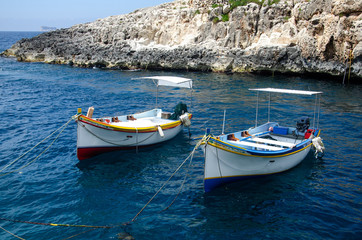 Fototapeta na wymiar Small tourist boats moored in the Wied iz-Zurrieq harbor near the Blue Grotto sea caves in Malta.