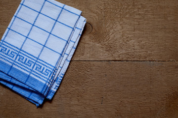 Folded napkin on wooden table background.