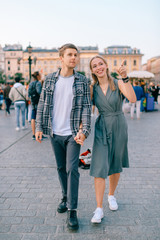 Happy loving couple smiling and walking throug the main square in Krakow (Cracow)