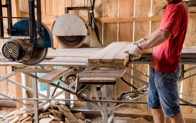 Modern sawmill. A carpenter works on woodworking the machine tool.