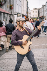 Cheerful man playing on the guitar outdoors