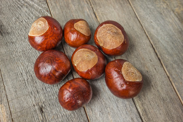 Chestnuts on grey rustic wooden table. Top view