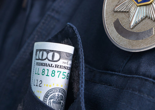 100 US Dollar Bill In A Pocket Of A Police Officer Uniform. Symbolic Image Of Bribe, Police Corruption. Close-up, Selective Focus.