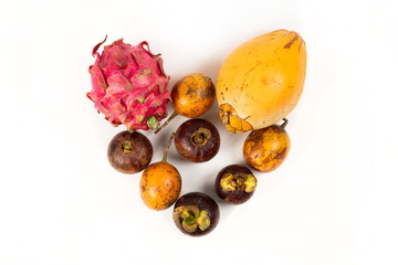 Useful for health tropical fruits in the shape of heart on white background