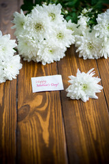 Obraz na płótnie Canvas bouquet of white chrysanthemums on wooden table