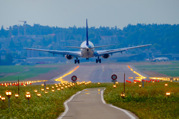 Fototapeta na wymiar Airplane landing at airport runway