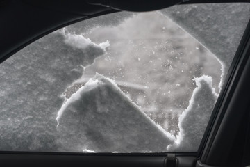 View from inside of car glass covered with frozen snowflakes