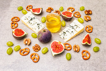 Cheese appetizer selection or wine snack set. Blue cheese, figs, honey, walnuts, pretzels