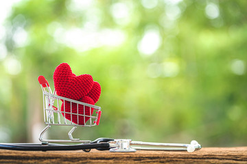 Shopping cart and the heart put on inside and stethoscope with showing  put on the wood in the...