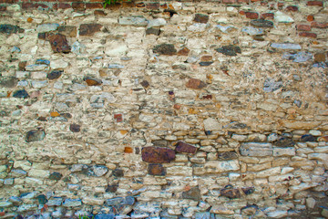 Old stone wall partially repaired with masonry