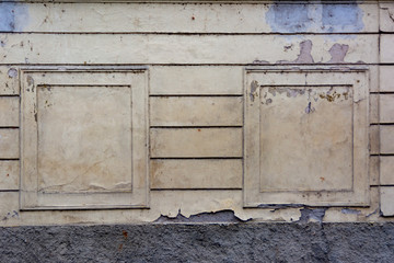 Symmetrically arranged false windows on the old battered wall of the building