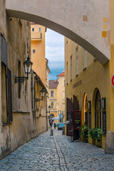 Obraz premium A narrow, deserted, cozy street in an old European city with open doors to shops