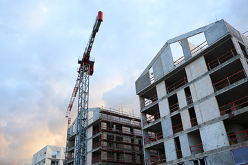 Real estate developers constructing multi story prefabricated flat blocks houses with construction...