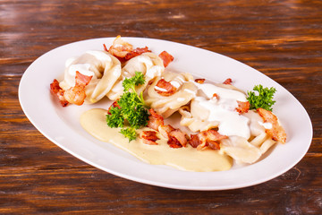 The meat fried bacon and sour cream sauce pelmeni