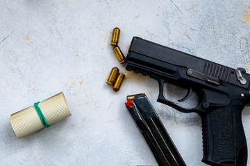 Gun with ammunition and shackle on black background. top view