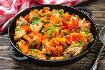 Chicken Stir fry with vegetables on wooden table.