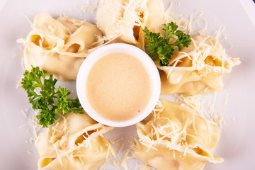 Cheese dumplings, are served with cheese sauce and grated cheese