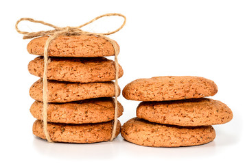 Homemade cookies. Five sweet cookie made from oatmeal flour, stacked and tied with linen rope in rustic style and three next. Tasty biscuit in high resolution closeup isolated on white background.