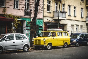 Vintage yellow van on the street in Berlin in autumn. Travel van concept. Travel and tourism in Berlin.