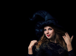Beautiful young witch in a black hat