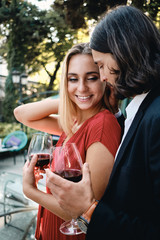 Young beautiful sensual couple happily drinking wine on date in restaurant outdoor