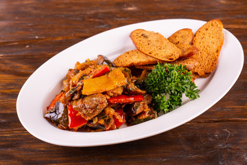 Stewed vegetables with toasts and greens