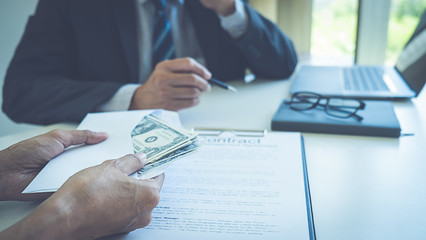 Businessman giving money while making deal to agreement a real estate contract and financial corporate.Bribe and corruption concept